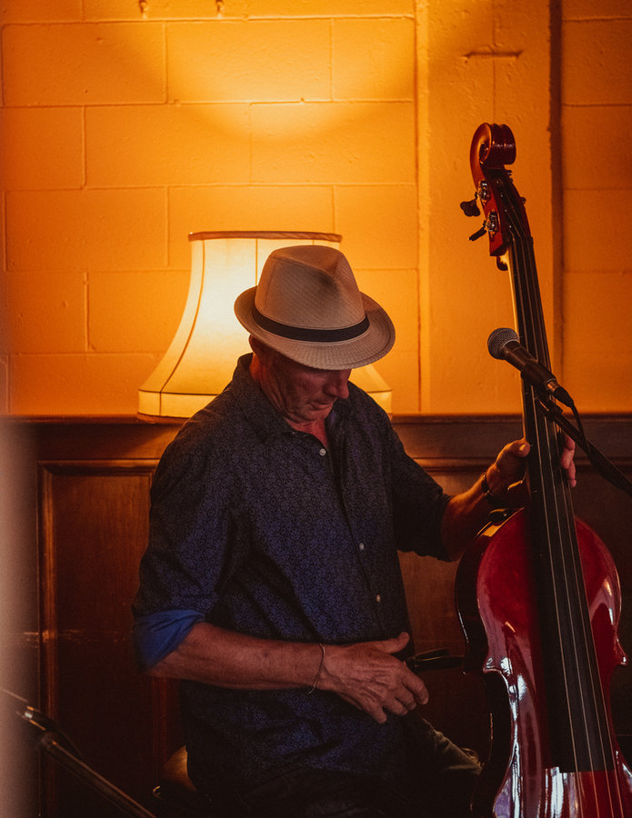 A musician with an upright bass inside Raumati Social Club