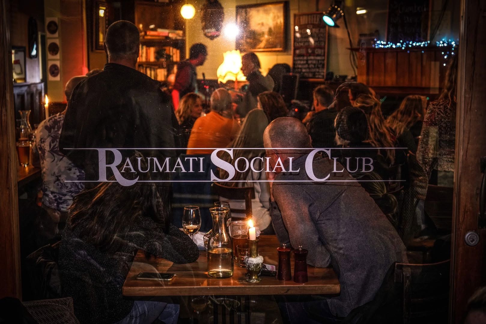 A busy evening viewed through the Raumati Social Club window